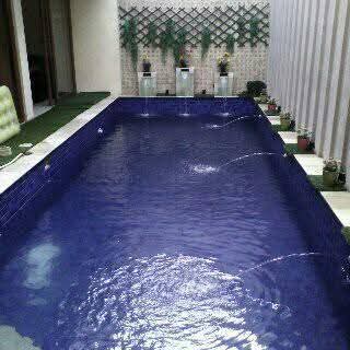 Kolam renang rumah pribadi dengan mozaik biru tua