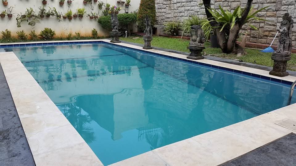 Kolam renang outdoor rumah pribadi dengan taman dan patung Bali
